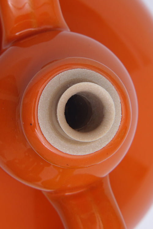 Dettaglio della bocca di una brocca arancione vuota per Olio Extravergine di Oliva Coratina